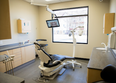 A dental office with a dental chair and a window.