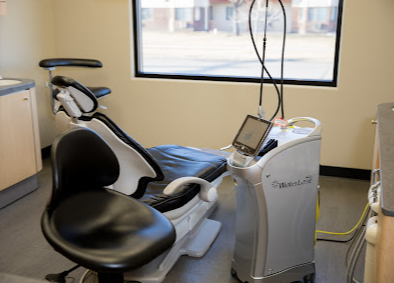 A dental office with a dental chair and a machine