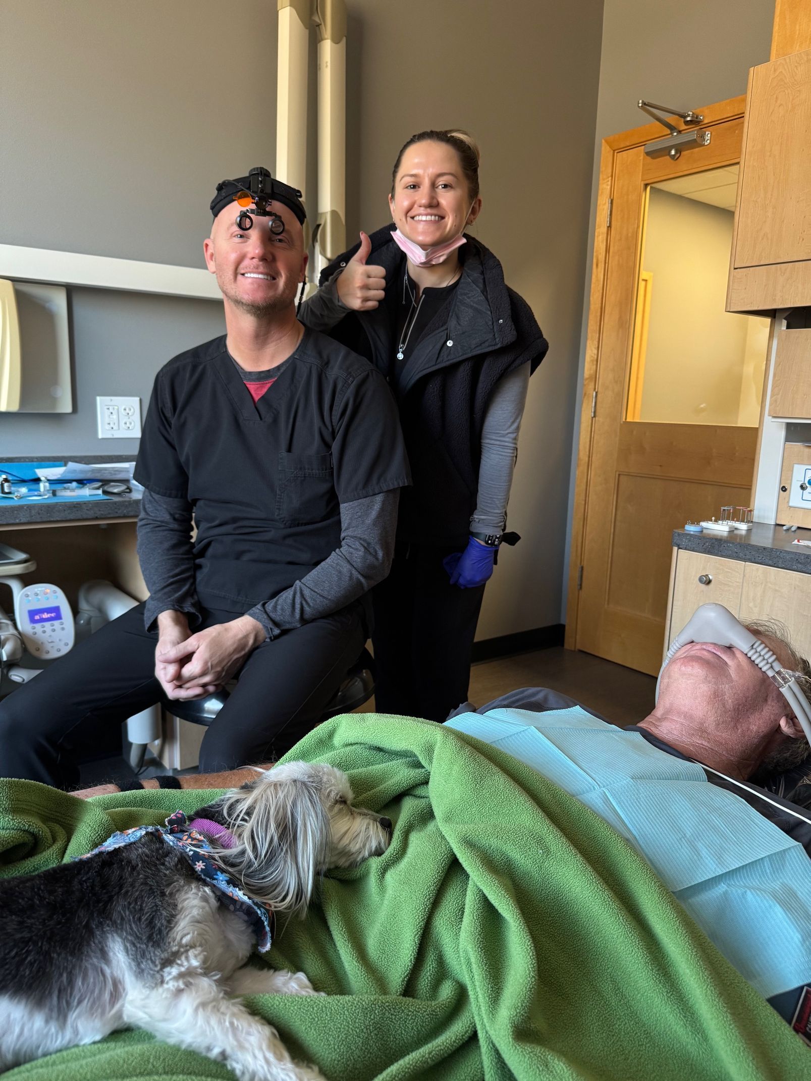 A small dog is sleeping on a green blanket