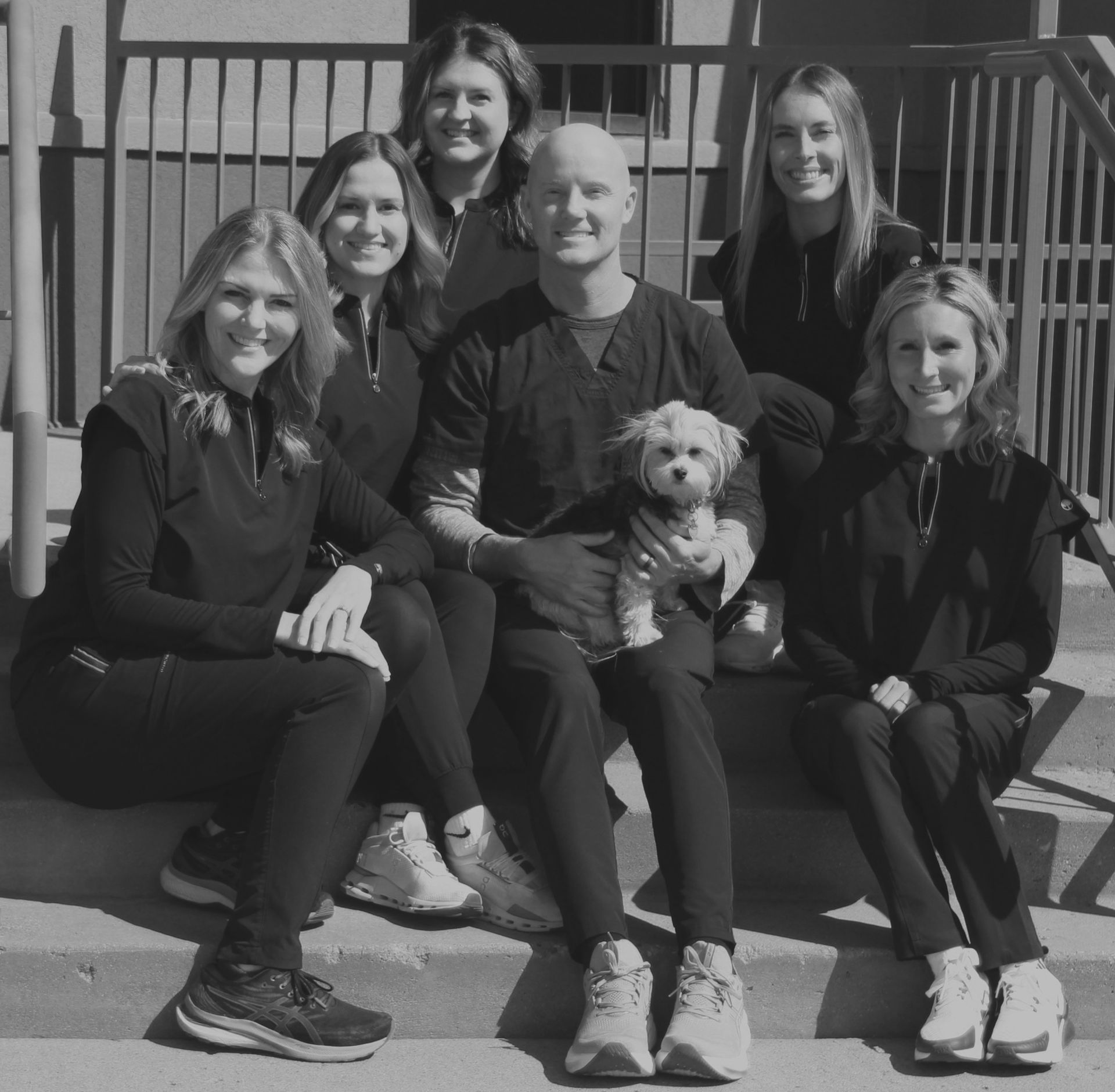 A group of people posing for a picture with a dog