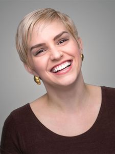 A woman with short blonde hair is smiling for the camera