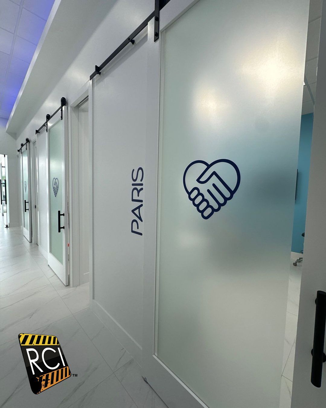 A hallway with a sliding glass door that says paris