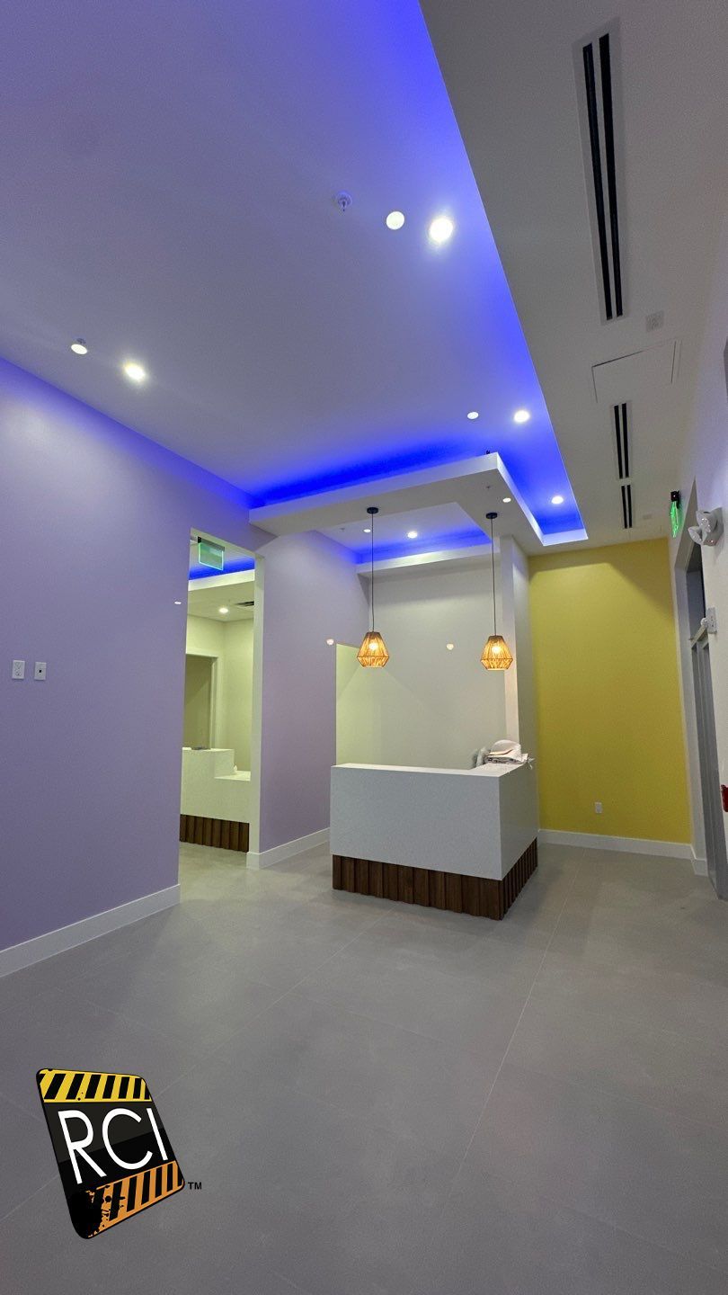A room with purple and yellow walls and blue lights on the ceiling.