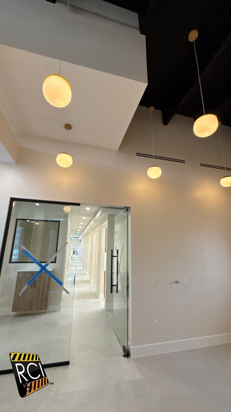 An empty room with a glass door and ceiling lights.