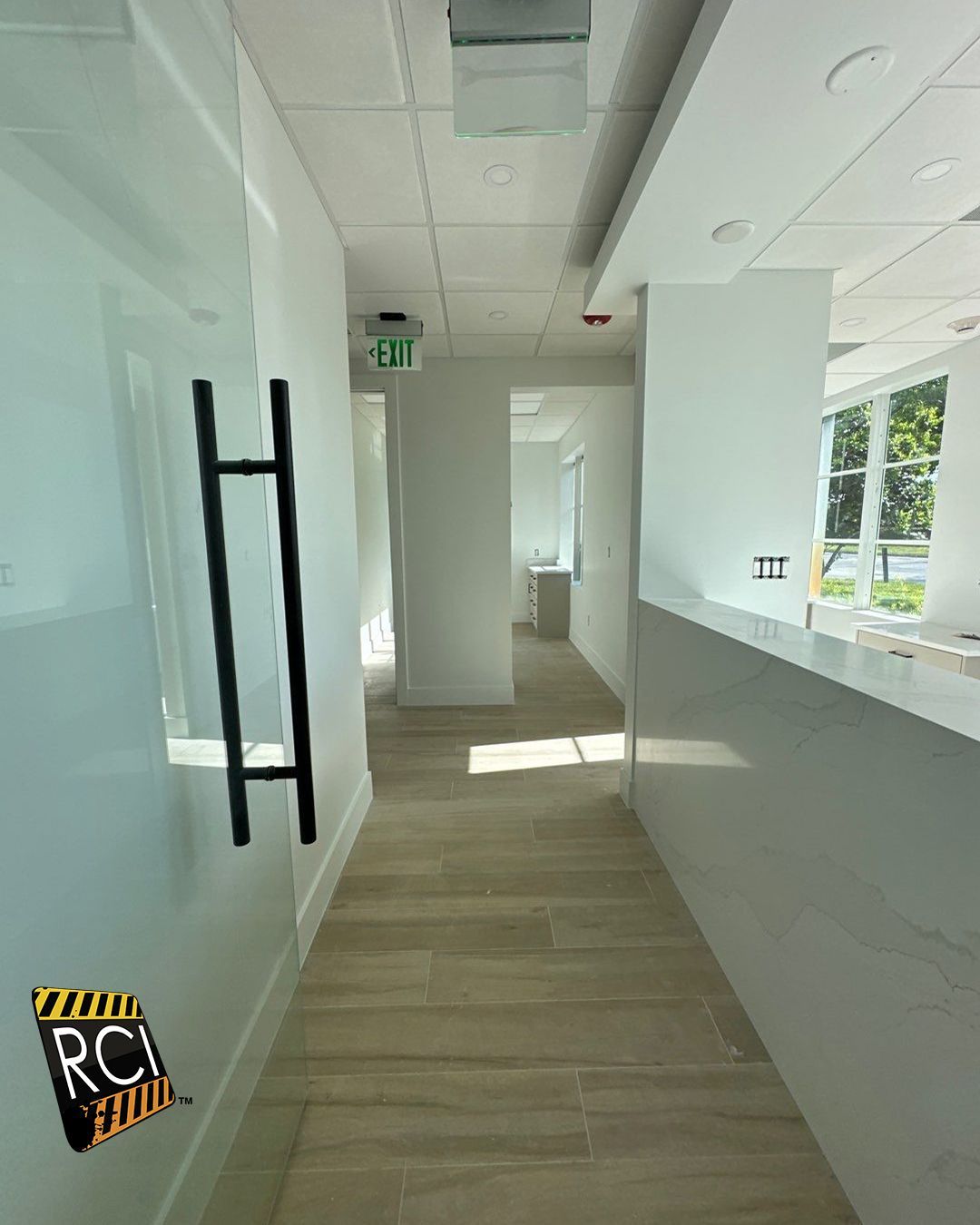 A long hallway leading to a reception desk in a building.