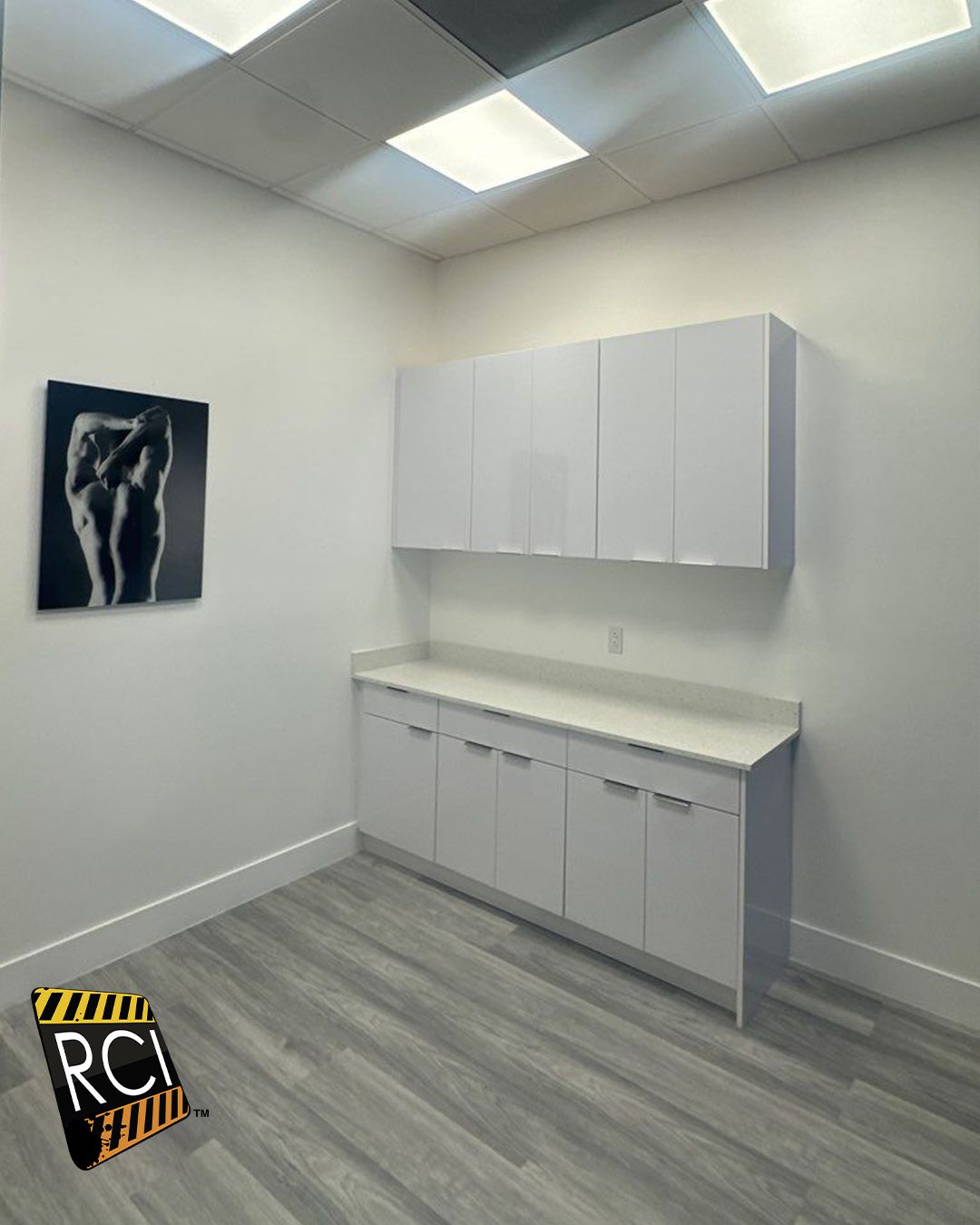 A room with white cabinets and a picture on the wall.