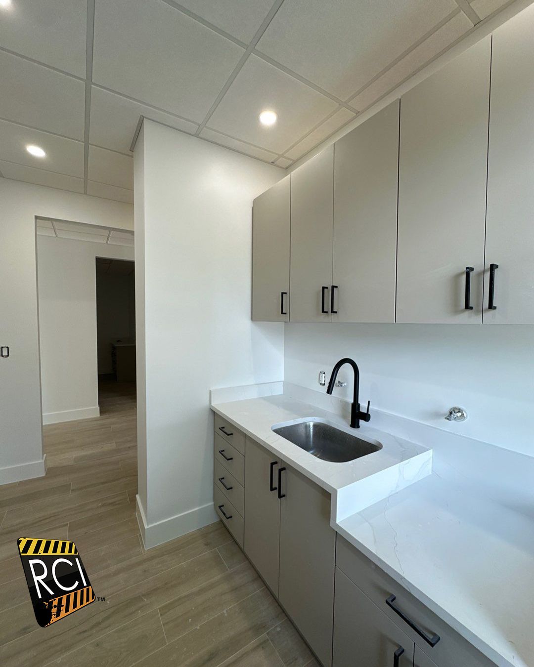 A kitchen with white cabinets and a sink.