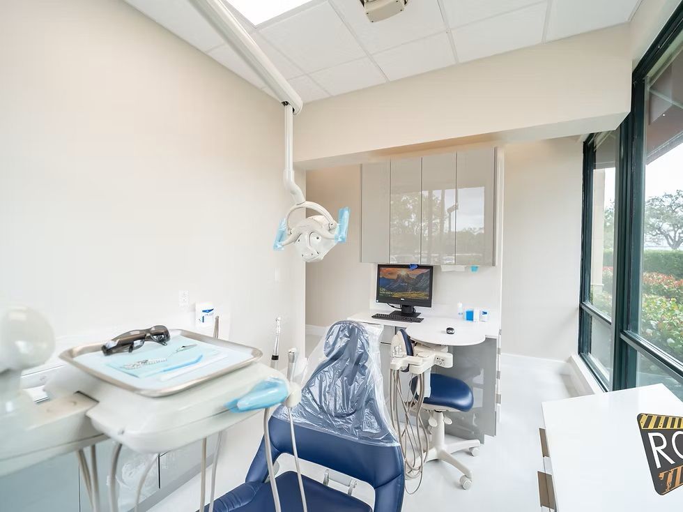 A dental office with a dental chair and a computer.