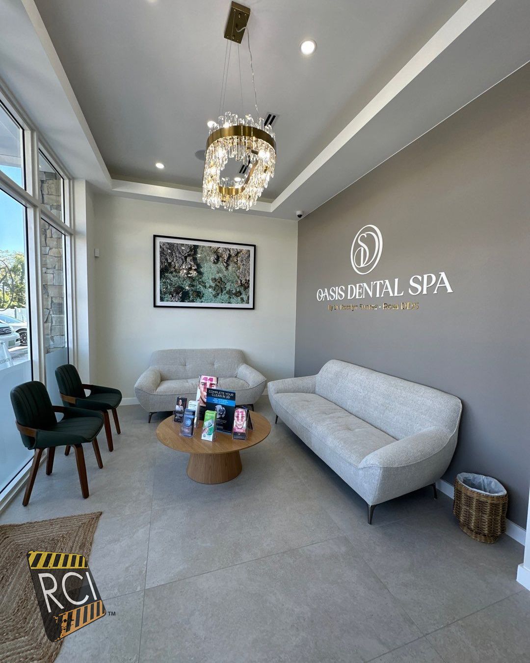 A waiting room with a couch , chairs , and a coffee table.