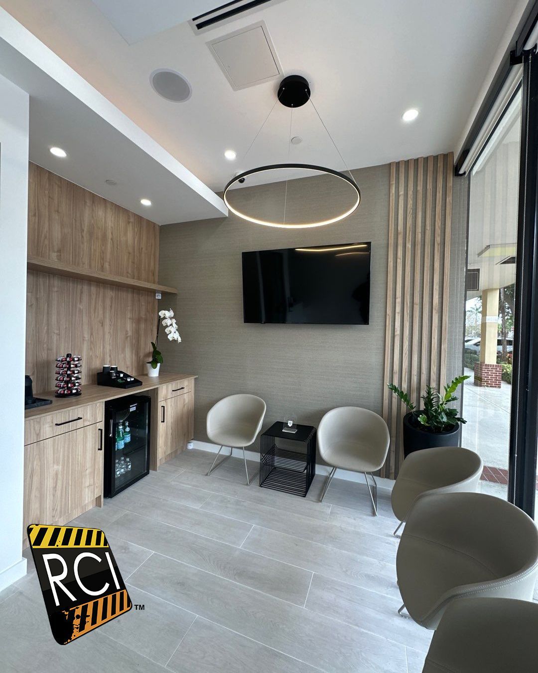 A waiting room with chairs and a flat screen tv