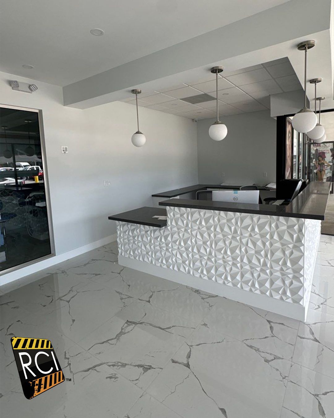 A large empty room with a counter and a marble floor.