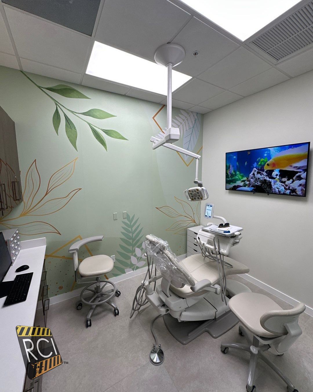 A dental office with a dental chair and a painting on the wall.