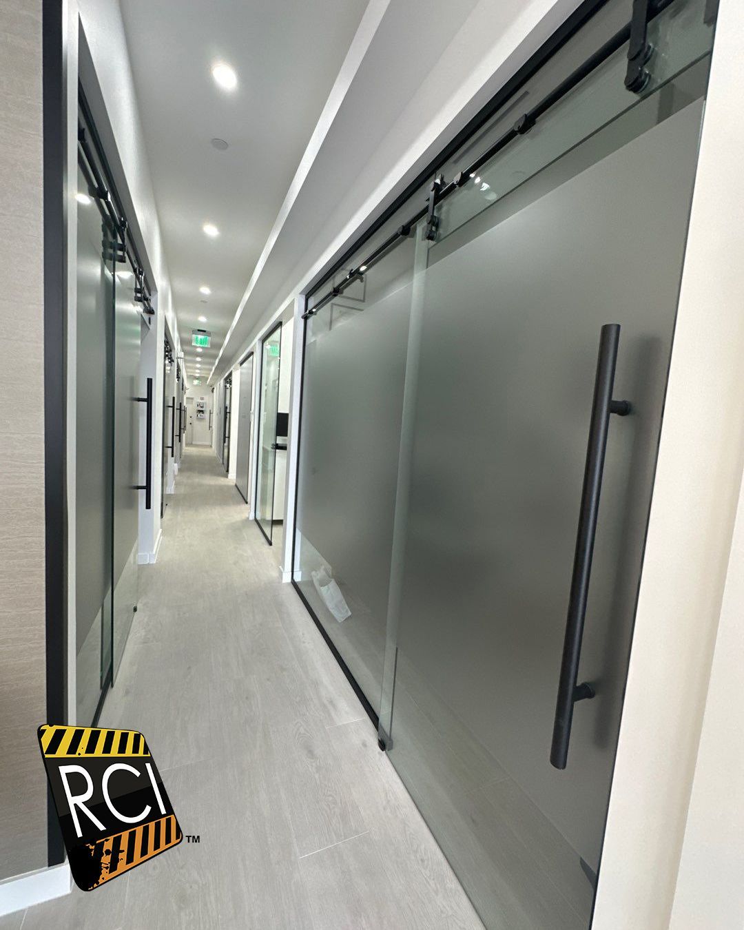 A long hallway with sliding glass doors and a sign that says rci