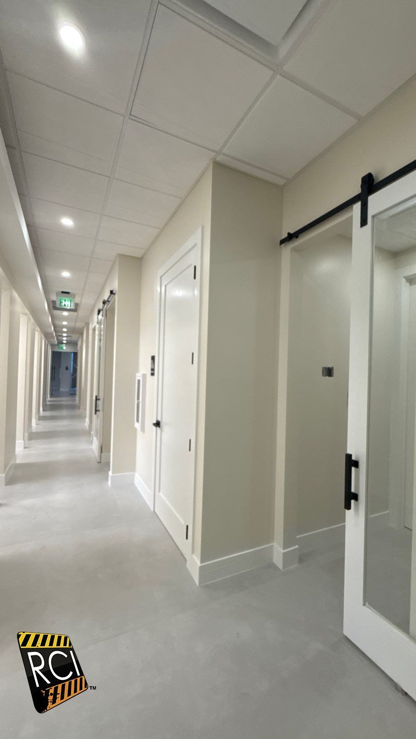 A long hallway with white walls and a sliding barn door