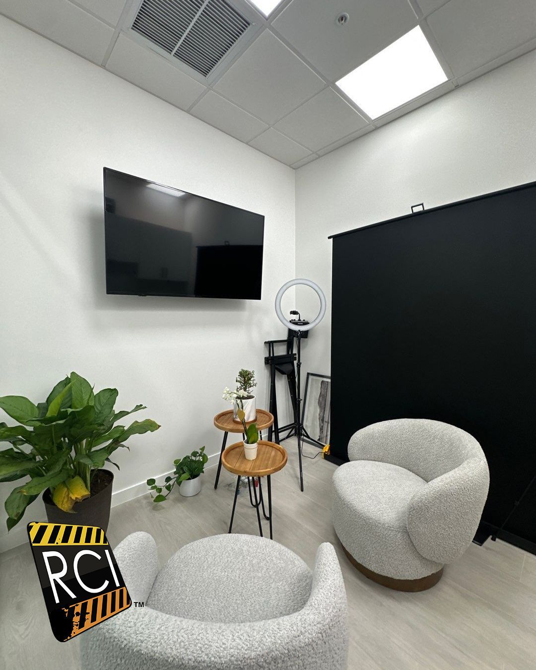 A room with two chairs and a flat screen tv