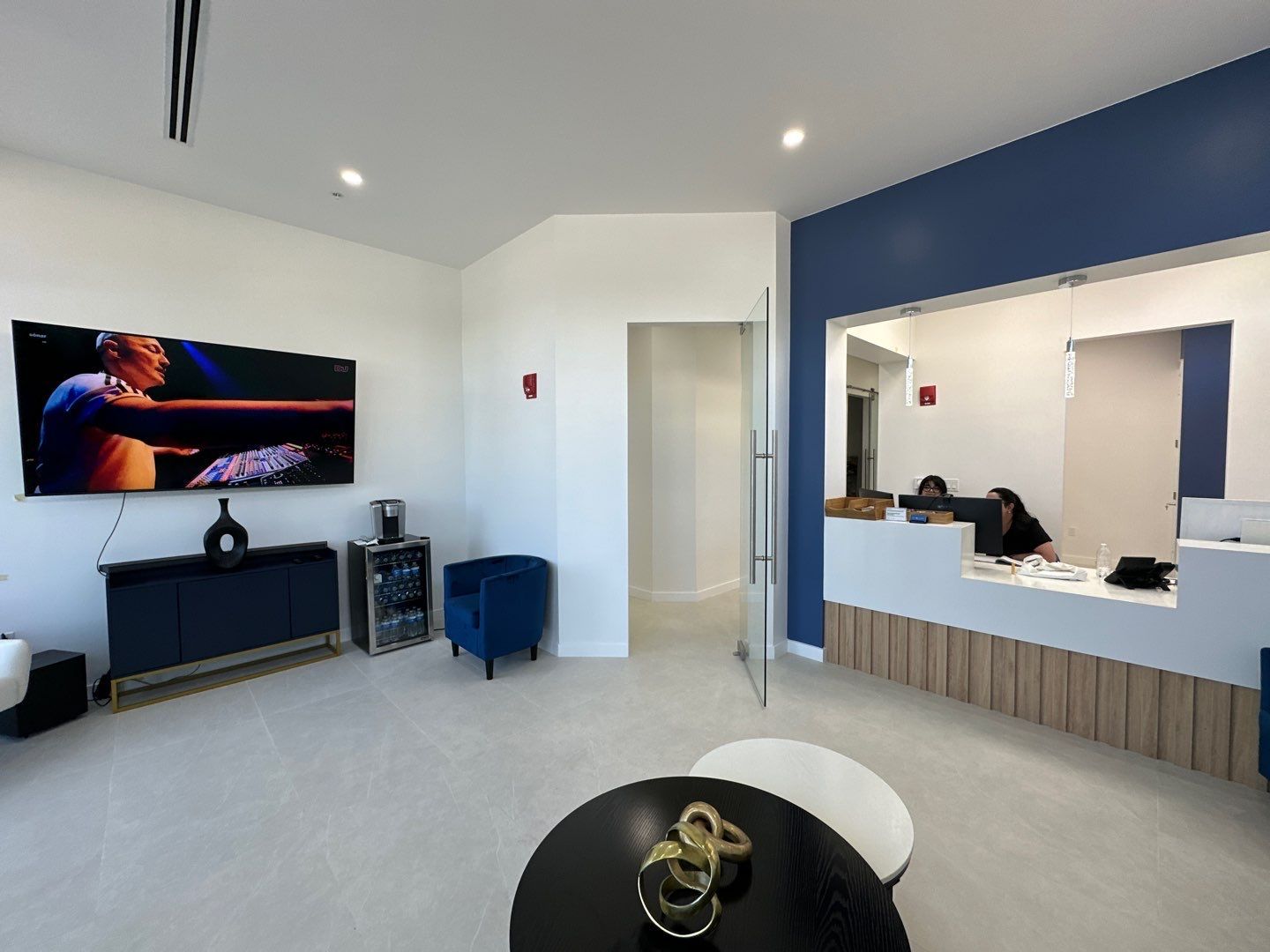 A living room with a table and a television on the wall.