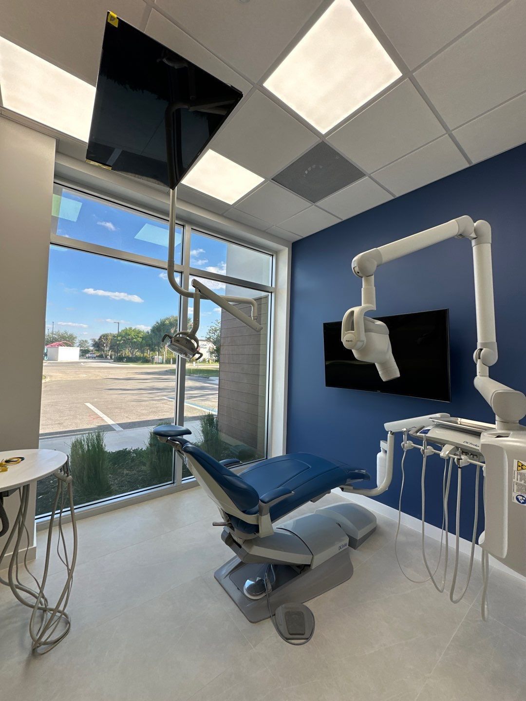 A dental office with a blue wall and a dental chair
