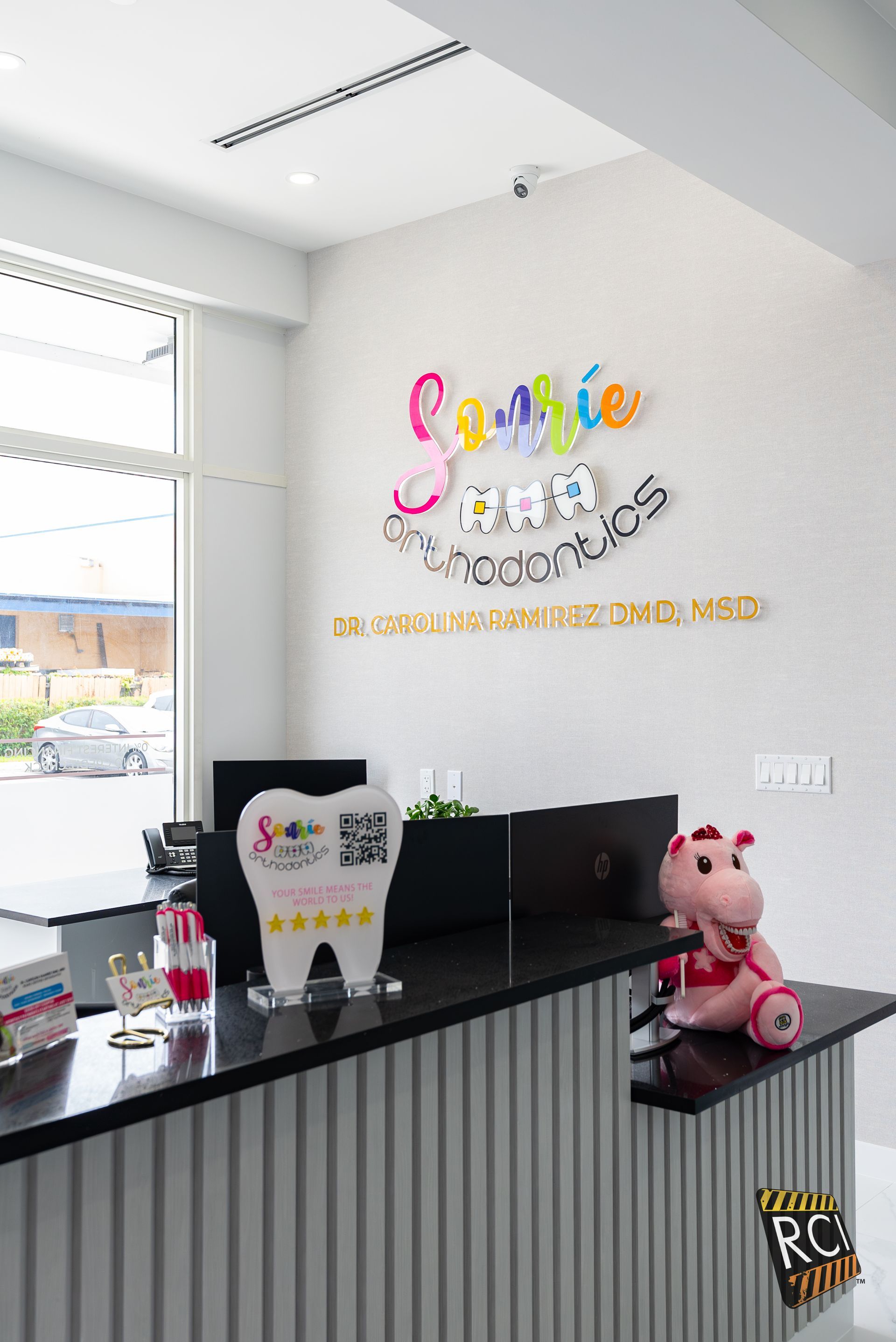 A dental office with a tooth and a stuffed animal on the counter.