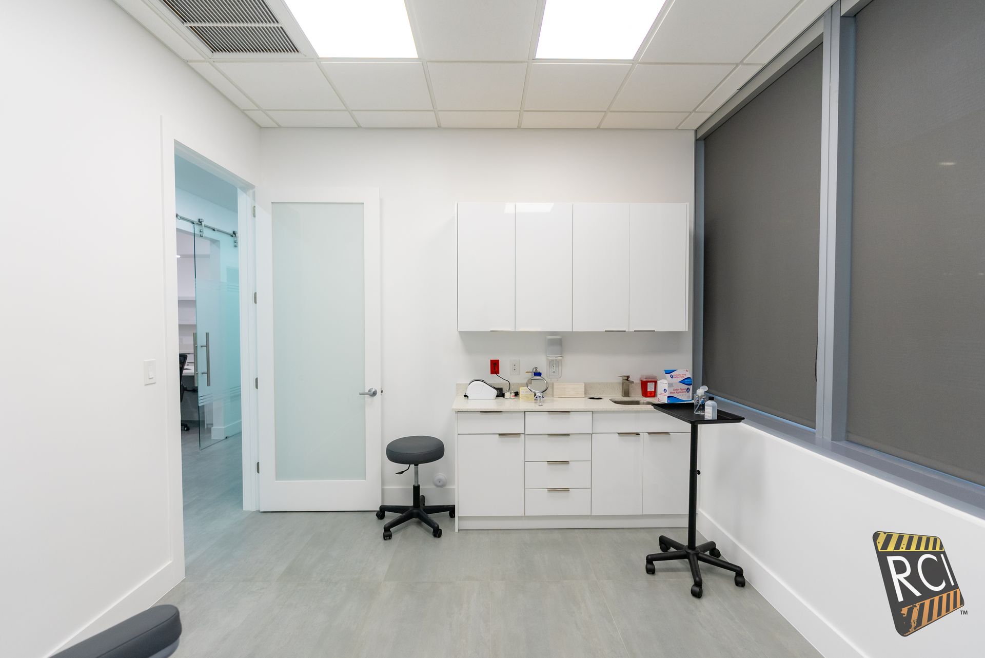 A room with white cabinets and a stool in it