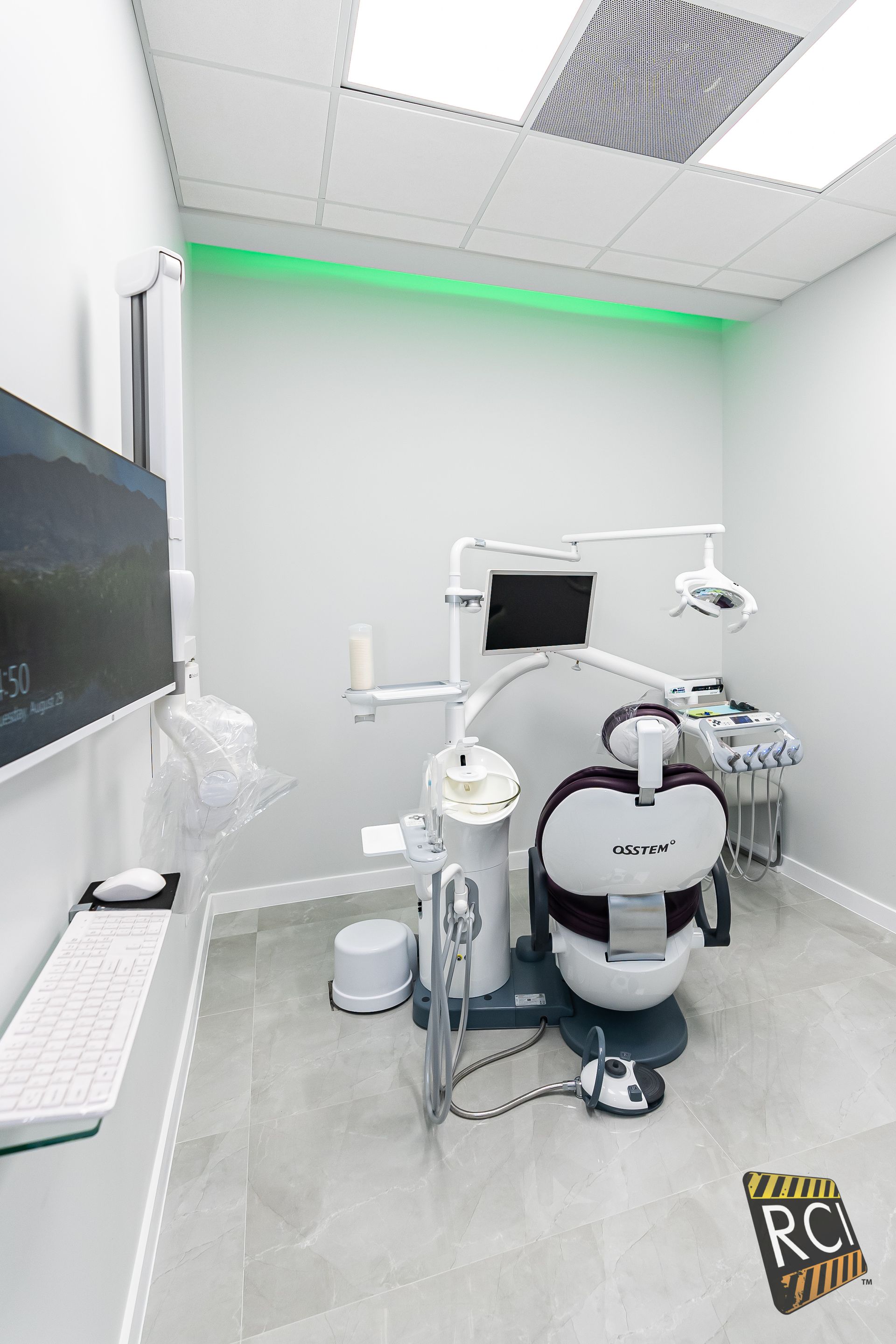 A dental office with a dental chair and a computer.
