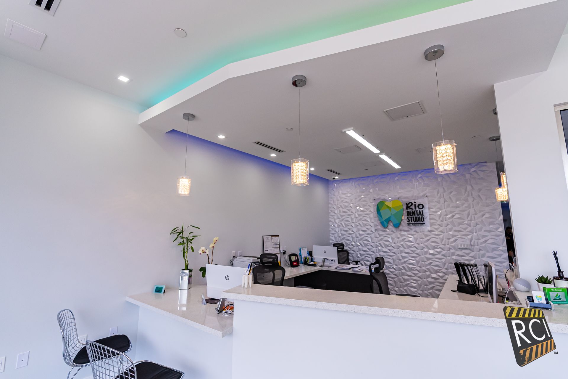 A dental office with a reception desk and chairs.