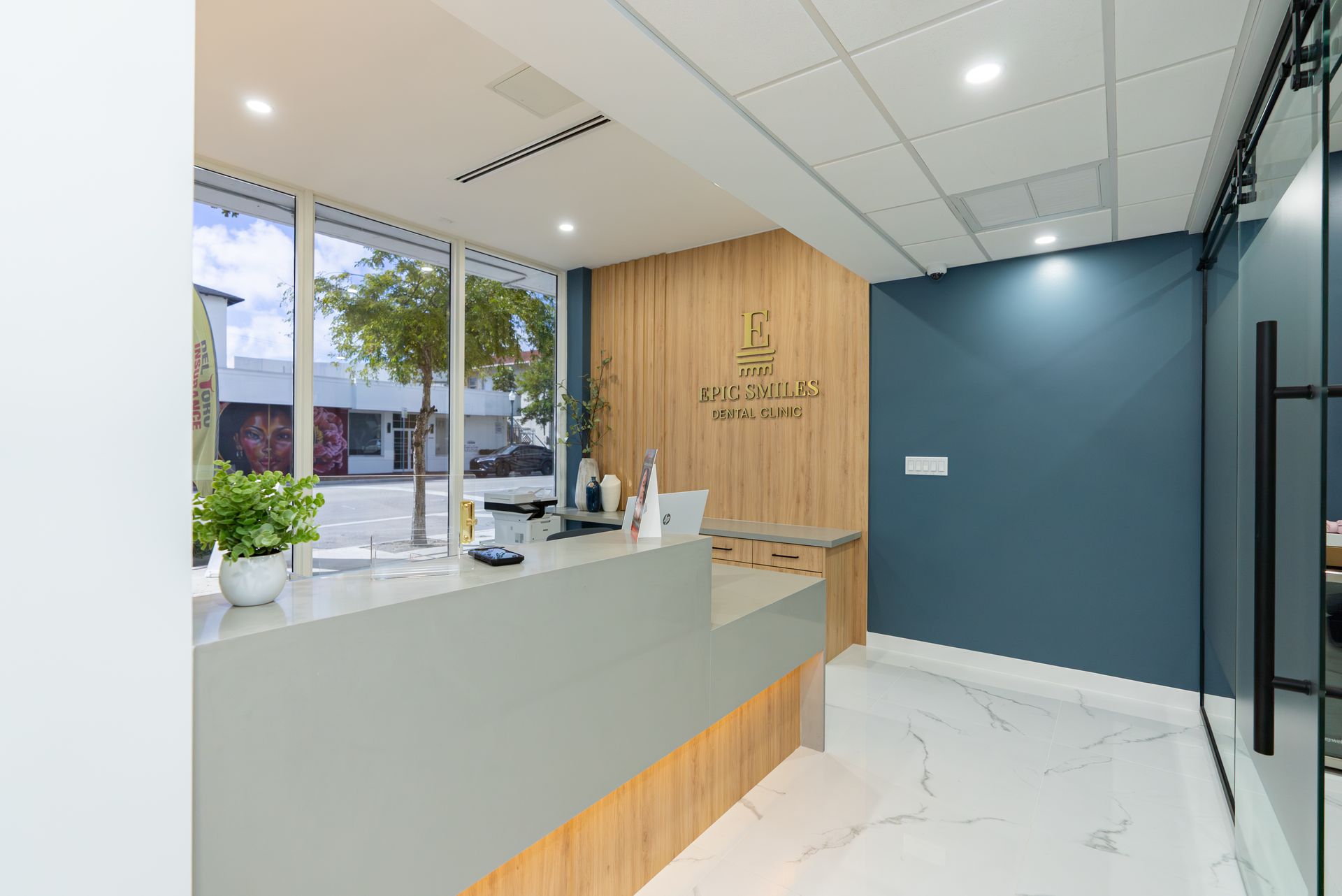 A dental office with a reception desk and a large window.