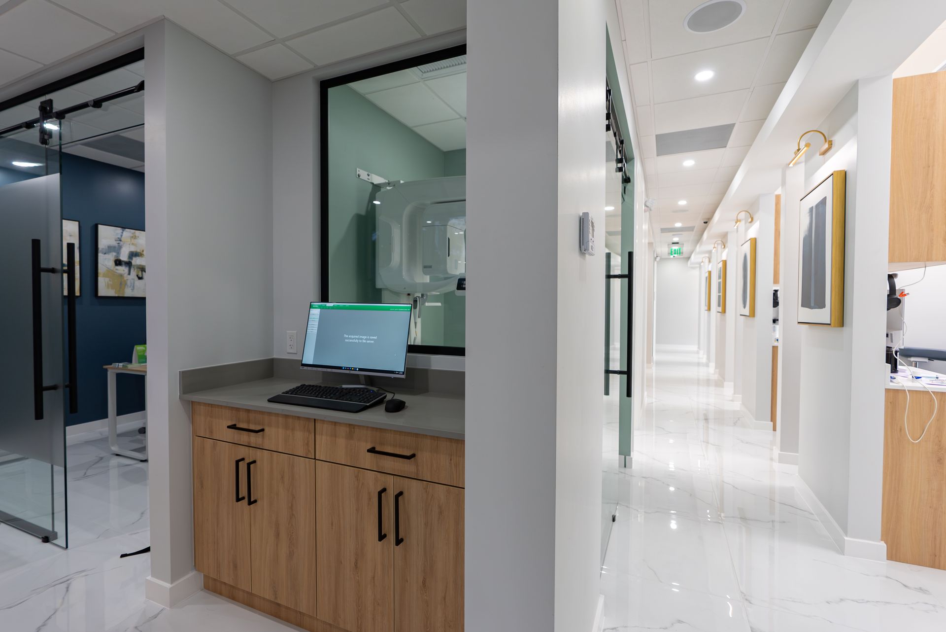A dental office with a computer on a counter in the hallway.