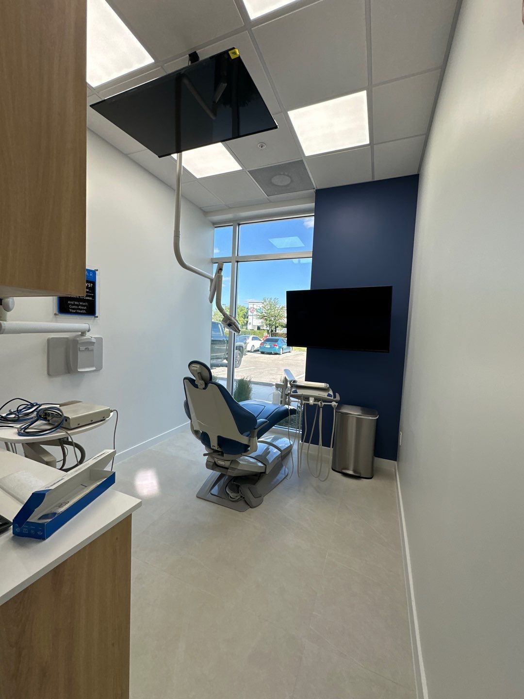 A dental office with a dental chair and a television.