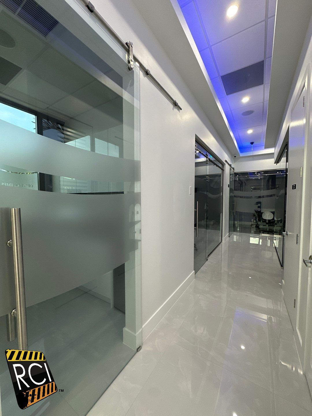 A long hallway with sliding glass doors and a blue ceiling