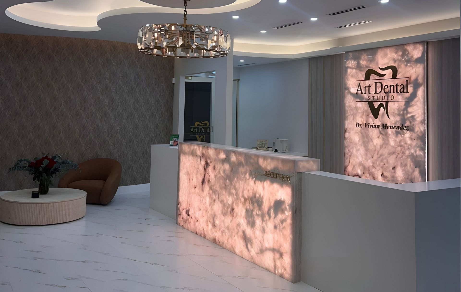Modern reception desk with pink marble panels in a stylish lobby with patterned walls and curved ceiling lights