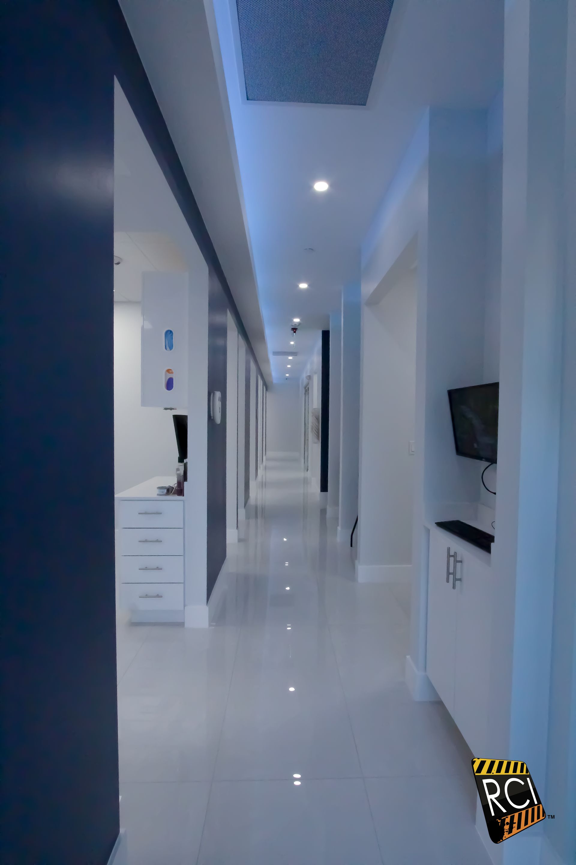 A long hallway in a dental office with blue and white walls