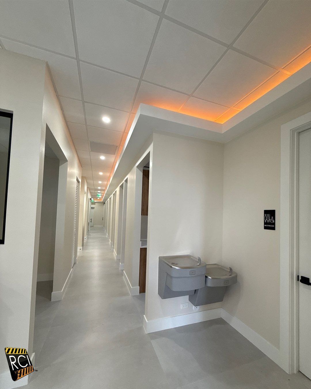 A long hallway with a fire extinguisher on the wall.