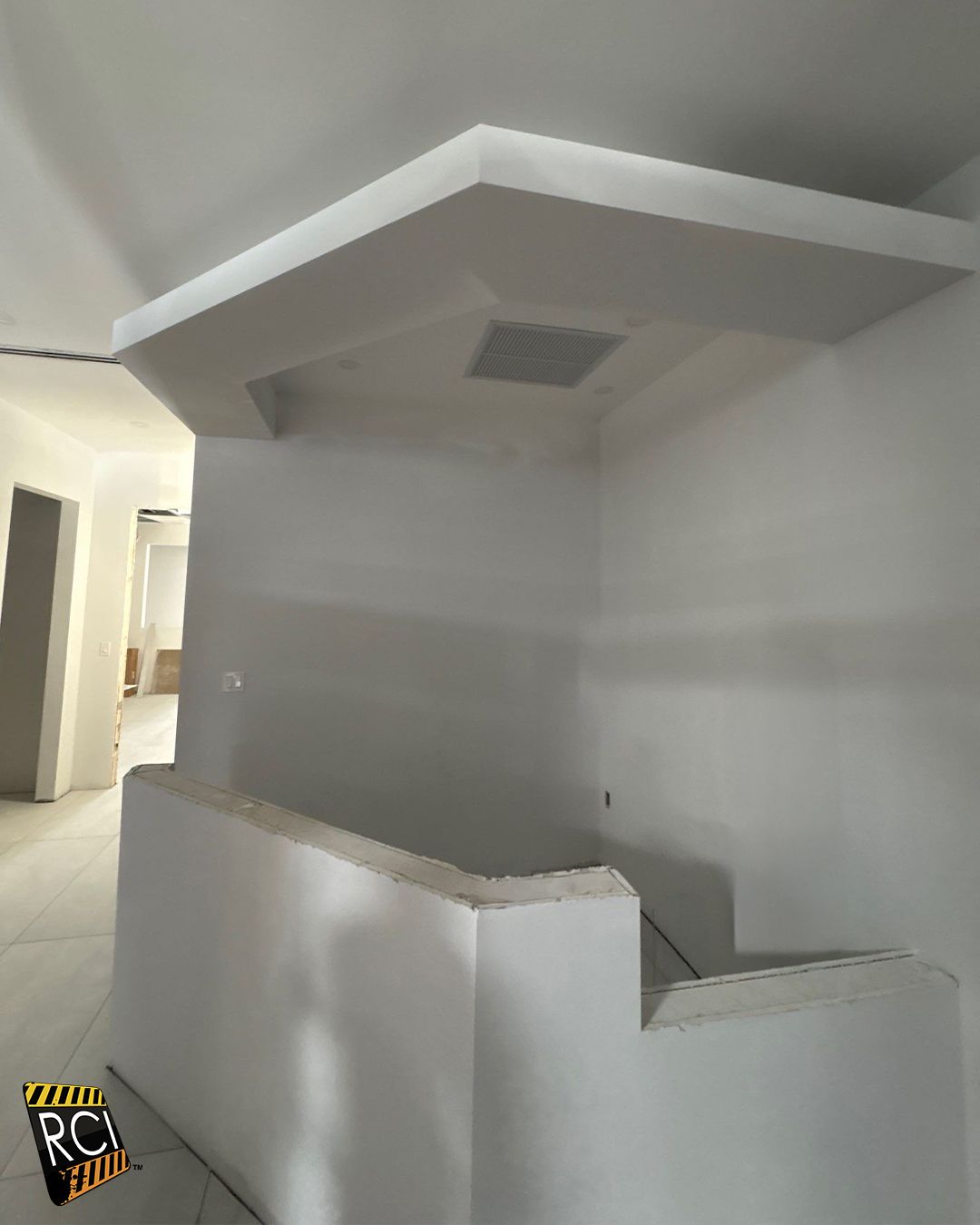 A white plaster structure with a built-in light fixture. In a construction setting.