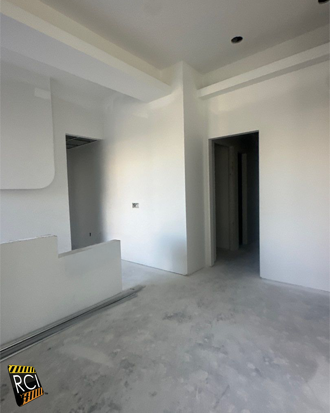 Interior construction view with drywall and unfinished concrete floor.