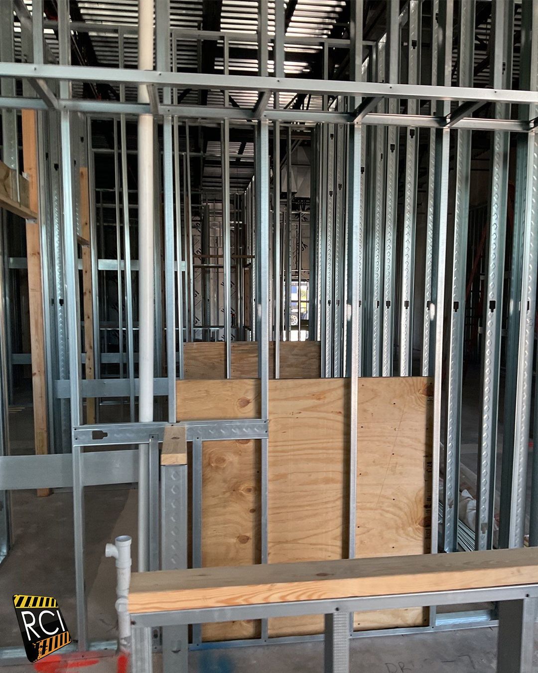 Metal studs and plywood form a room's unfinished walls during construction.
