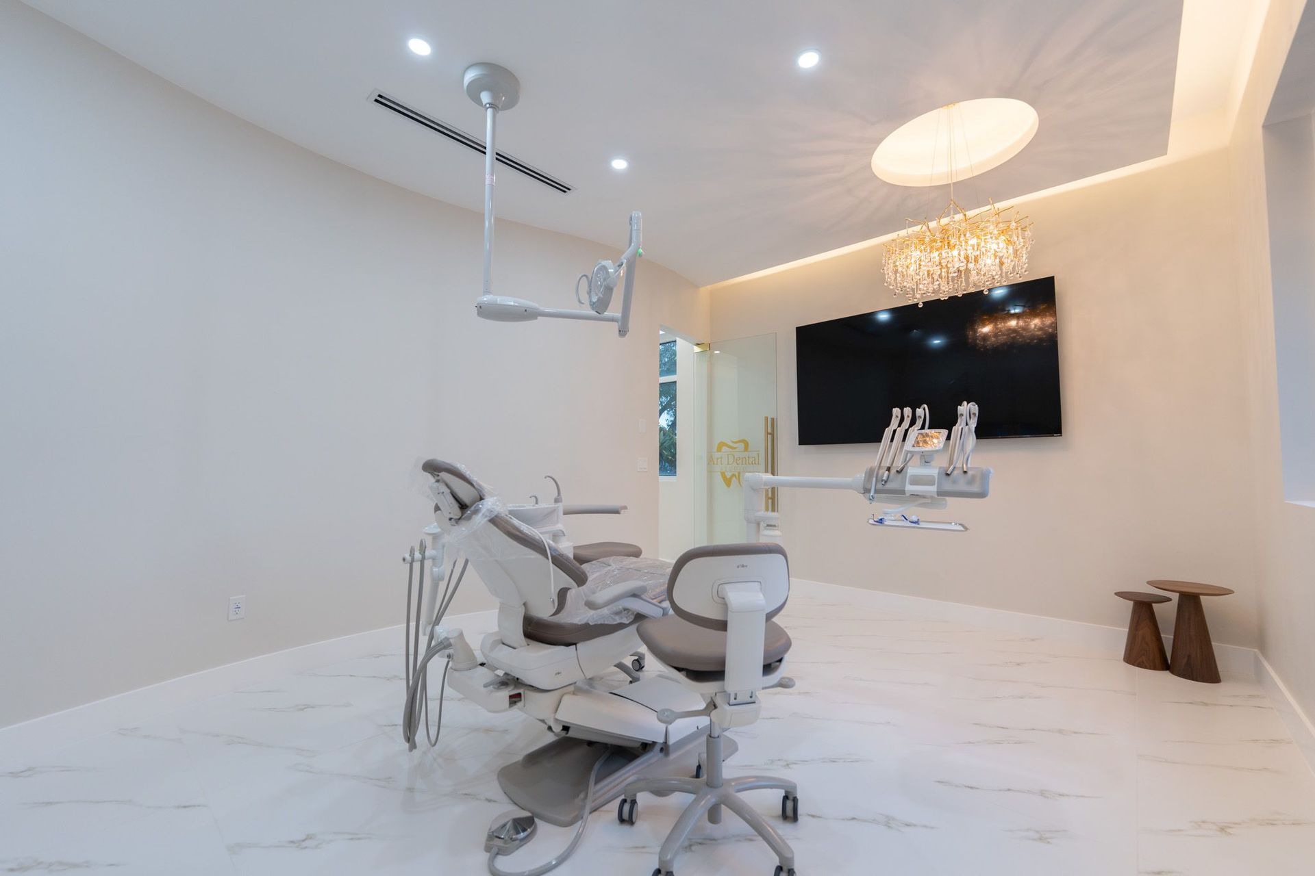 A dental office with a dental chair and a television on the wall.