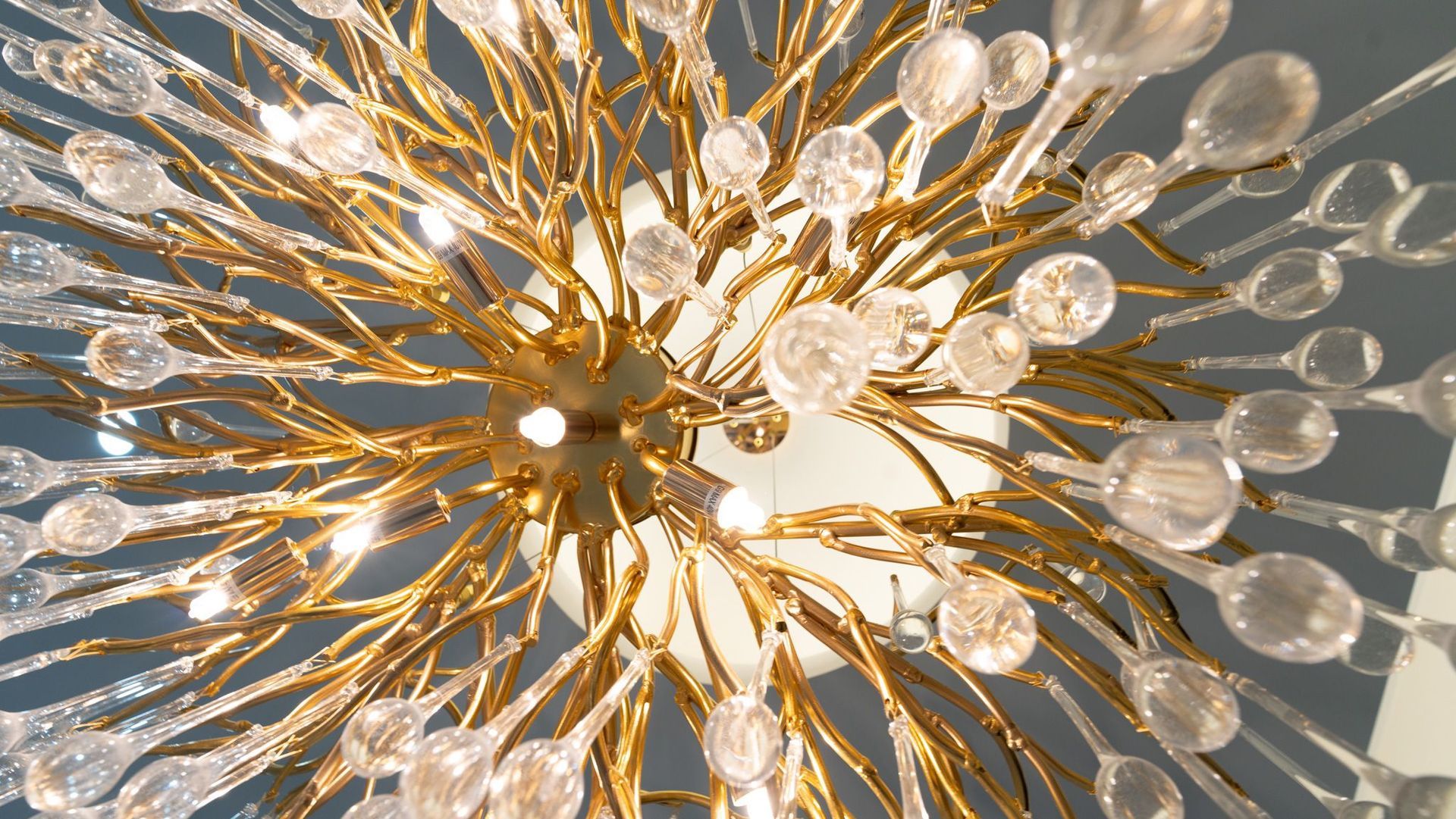 A close up of a chandelier with lots of crystals hanging from the ceiling.