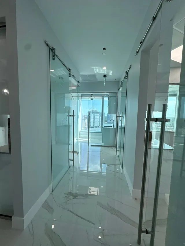 A hallway with sliding glass doors and marble floors