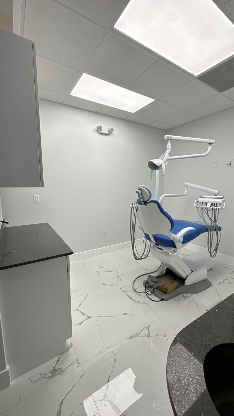 A dental office with a dental chair and a sink.