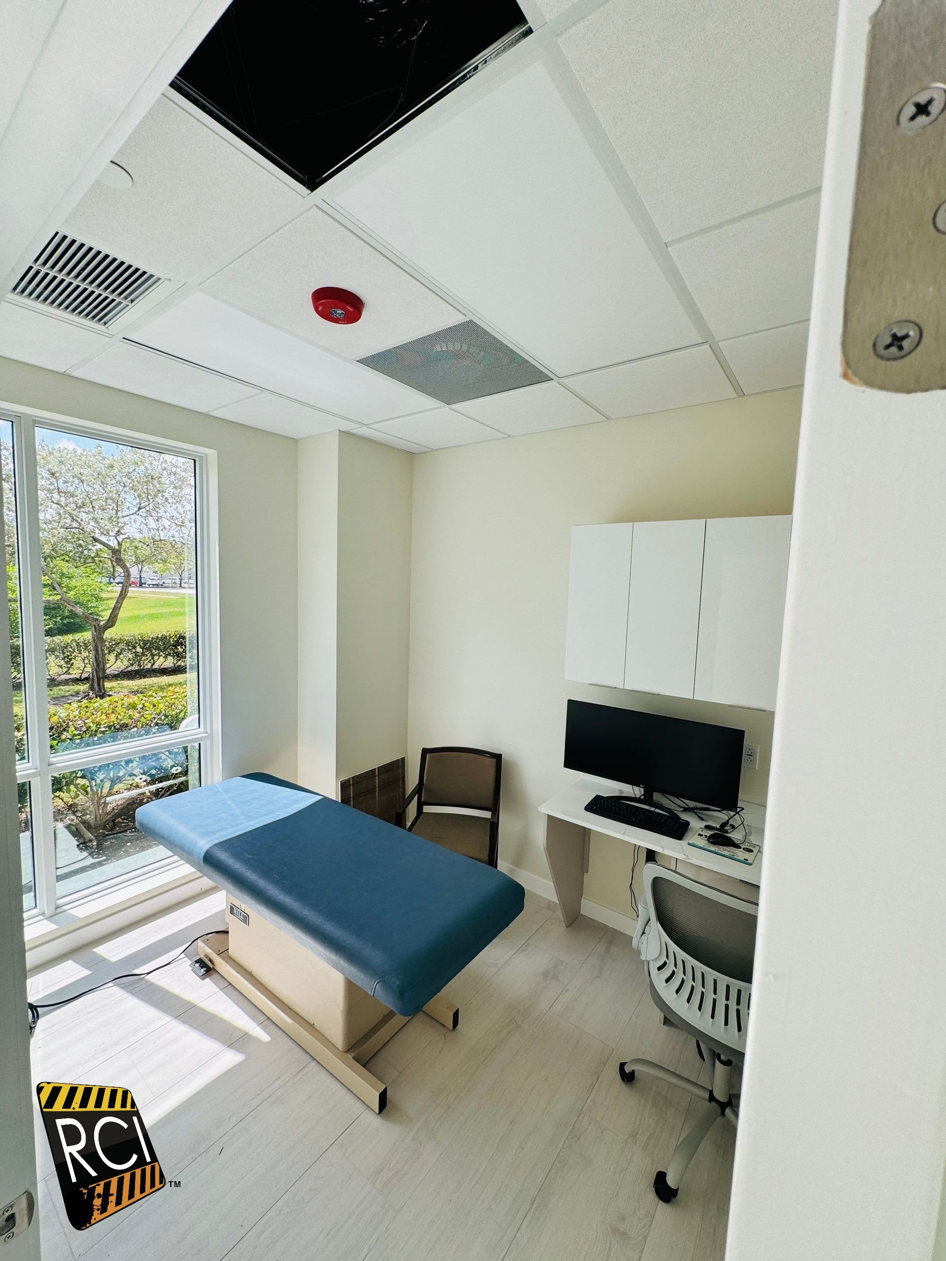 A doctor 's office with a blue table and a computer