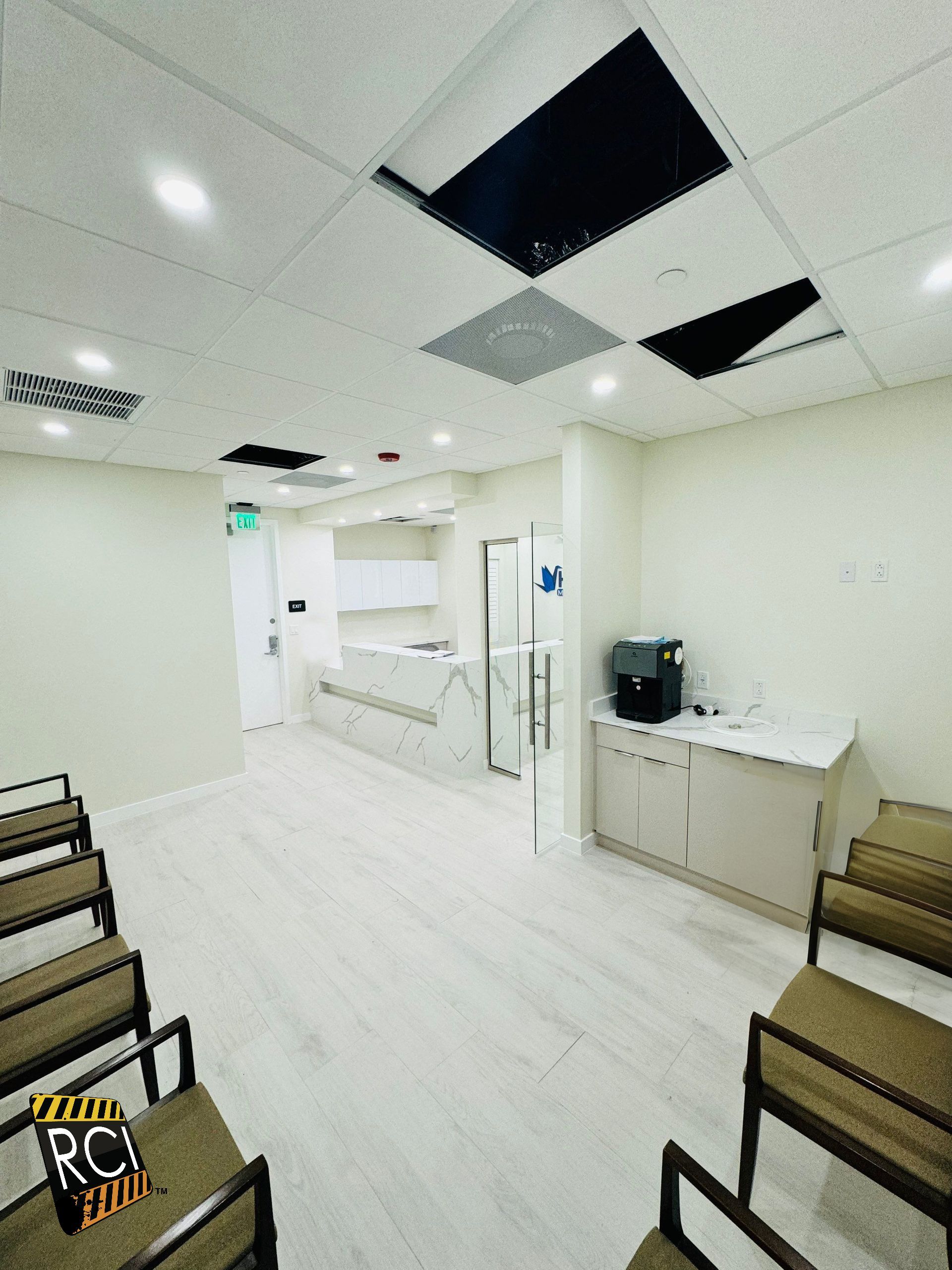 A waiting room with a row of chairs and a counter.