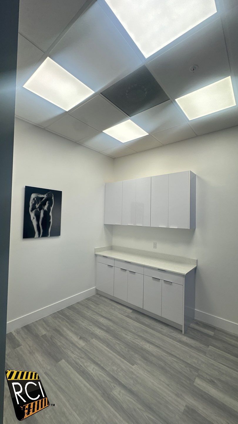 A room with white cabinets and a painting on the wall.