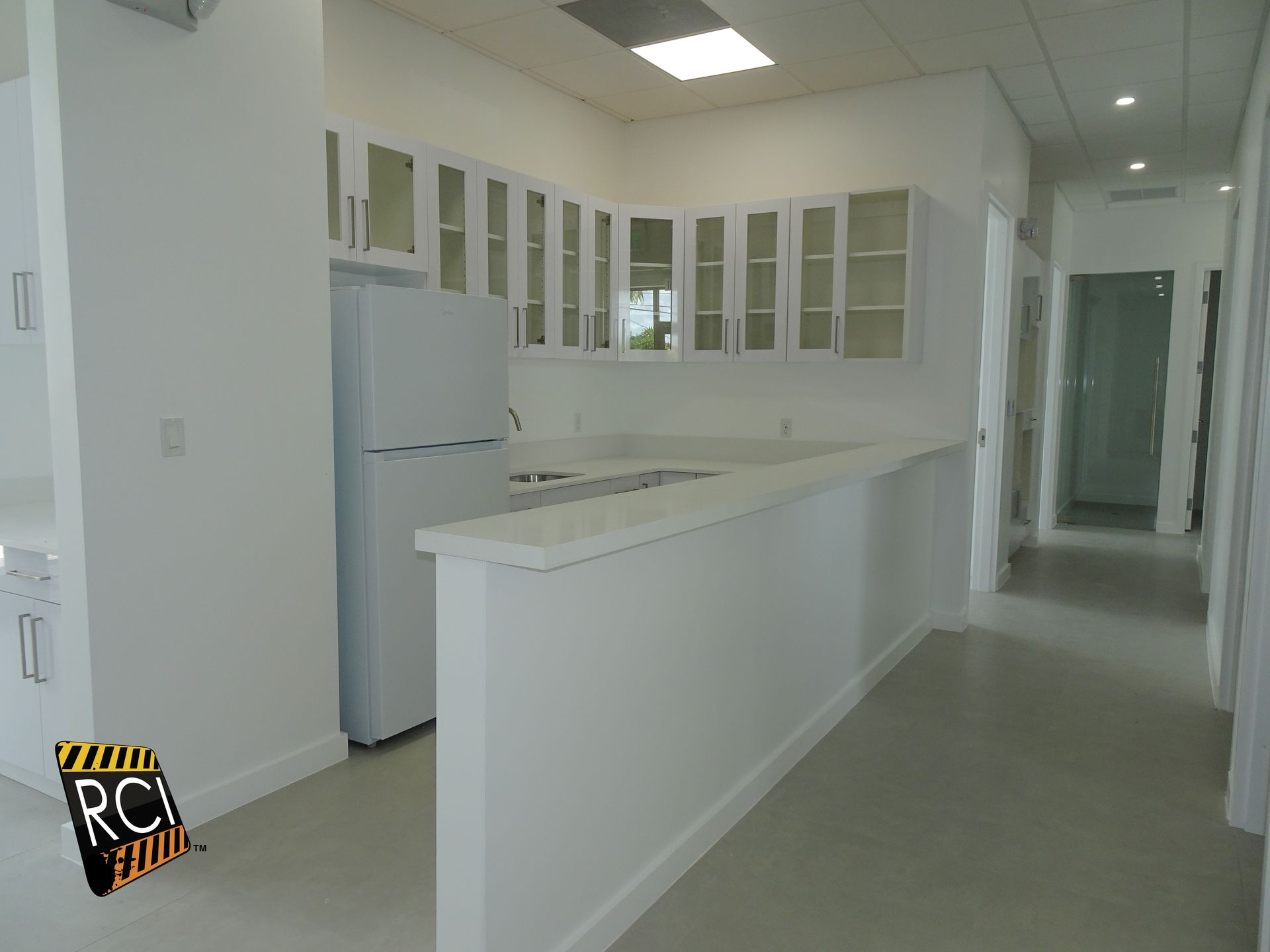 An empty kitchen with a sign that says rci on it