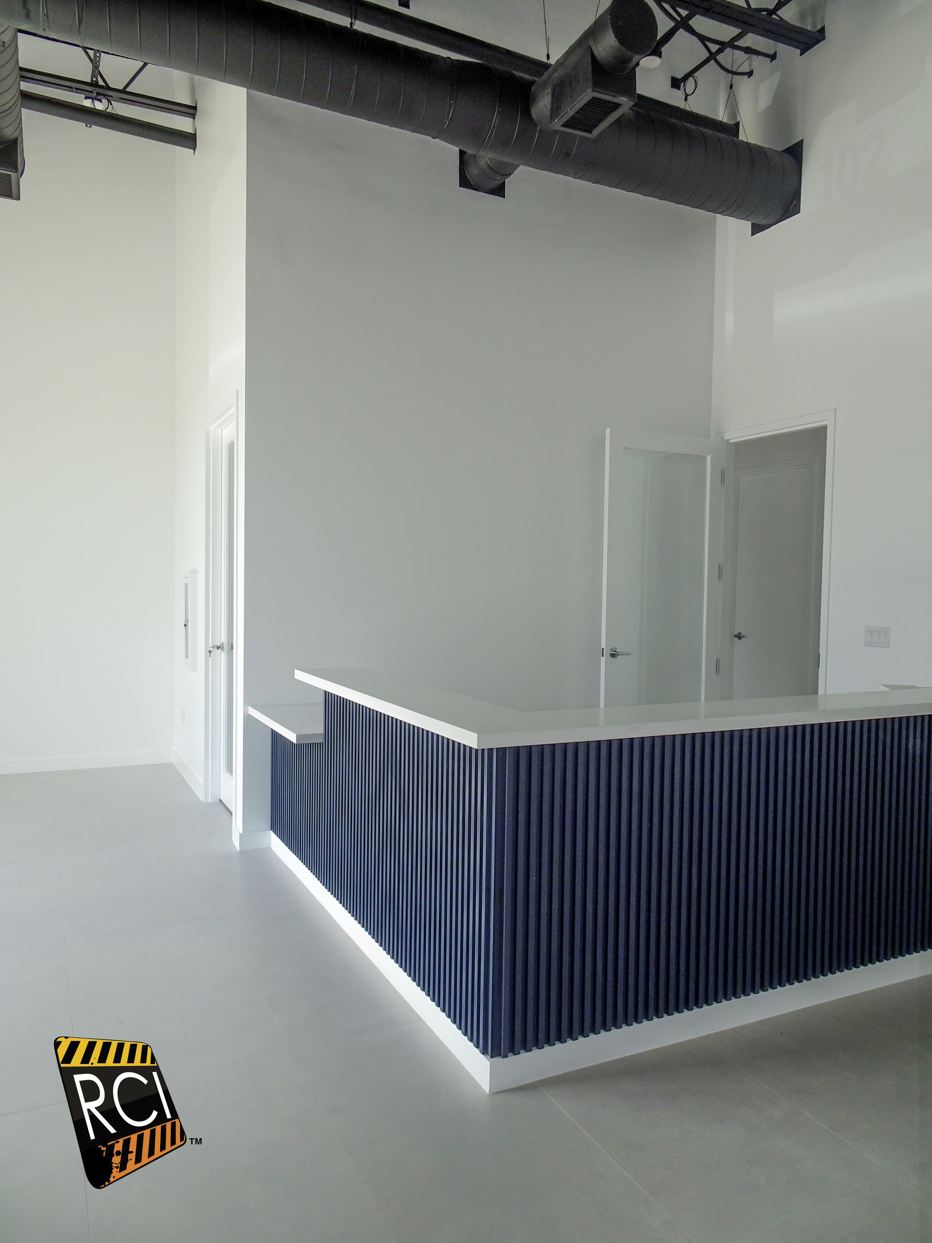 An empty room with a blue counter and a sign that says rcr studio