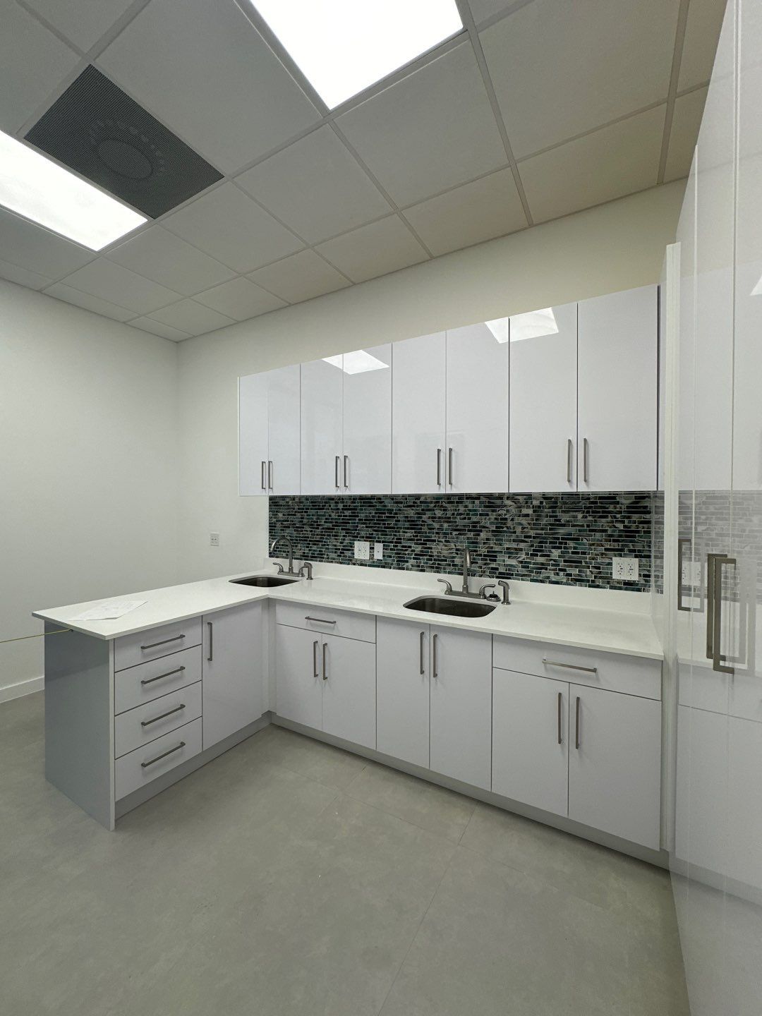 A kitchen with white cabinets and a large island
