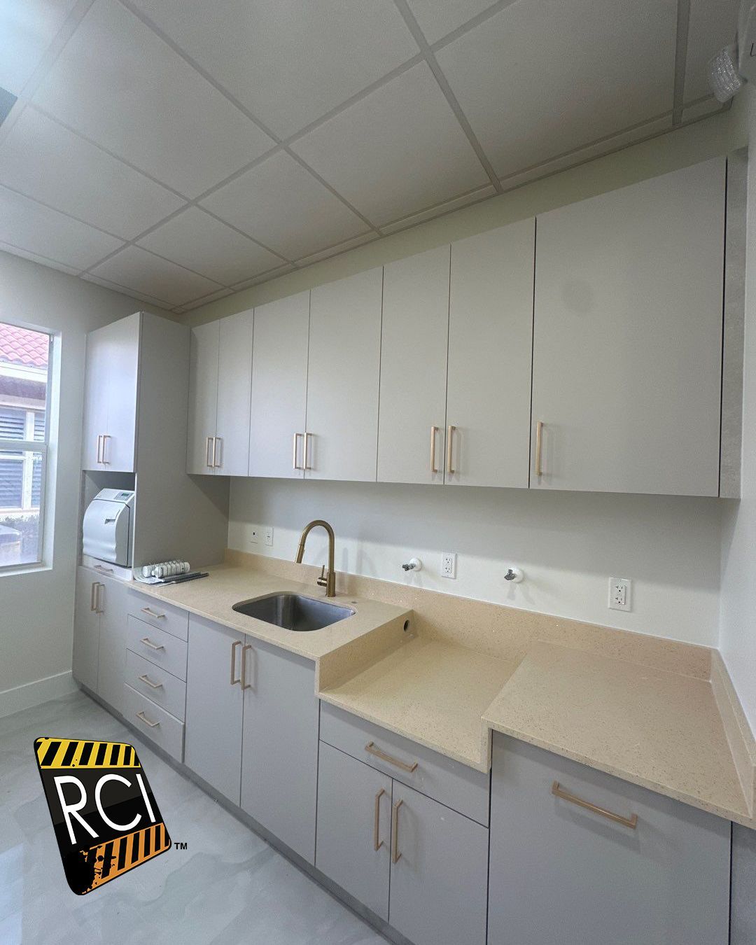 A kitchen with white cabinets and a sink.