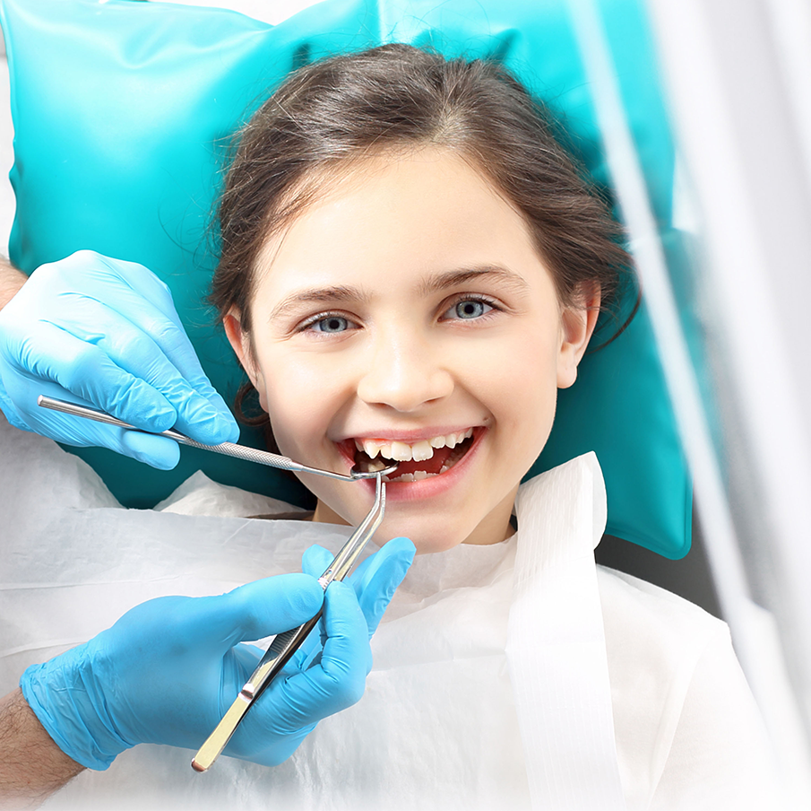 A little girl is getting her teeth examined by a dentist