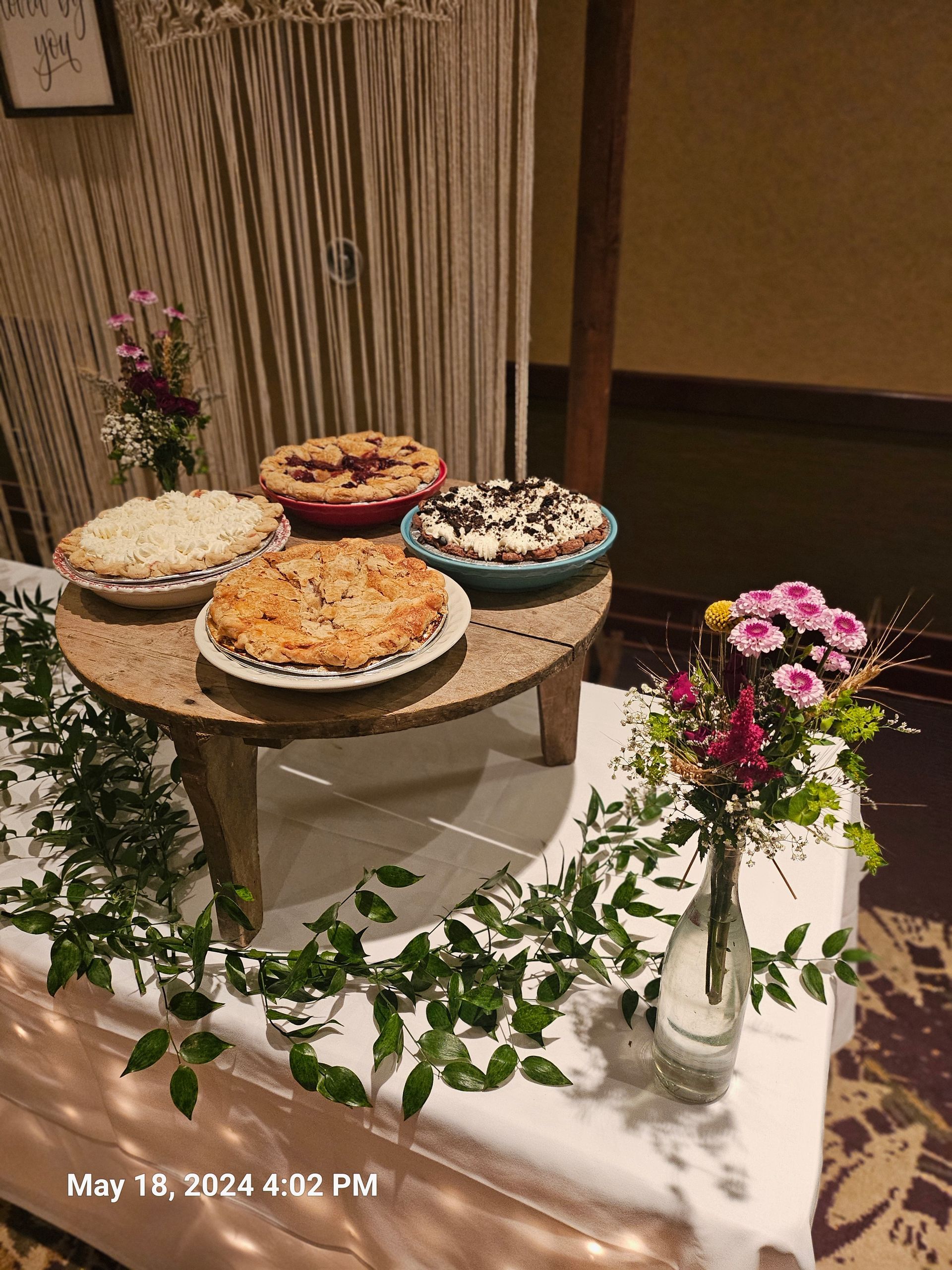A table with three pies on it and flowers on it