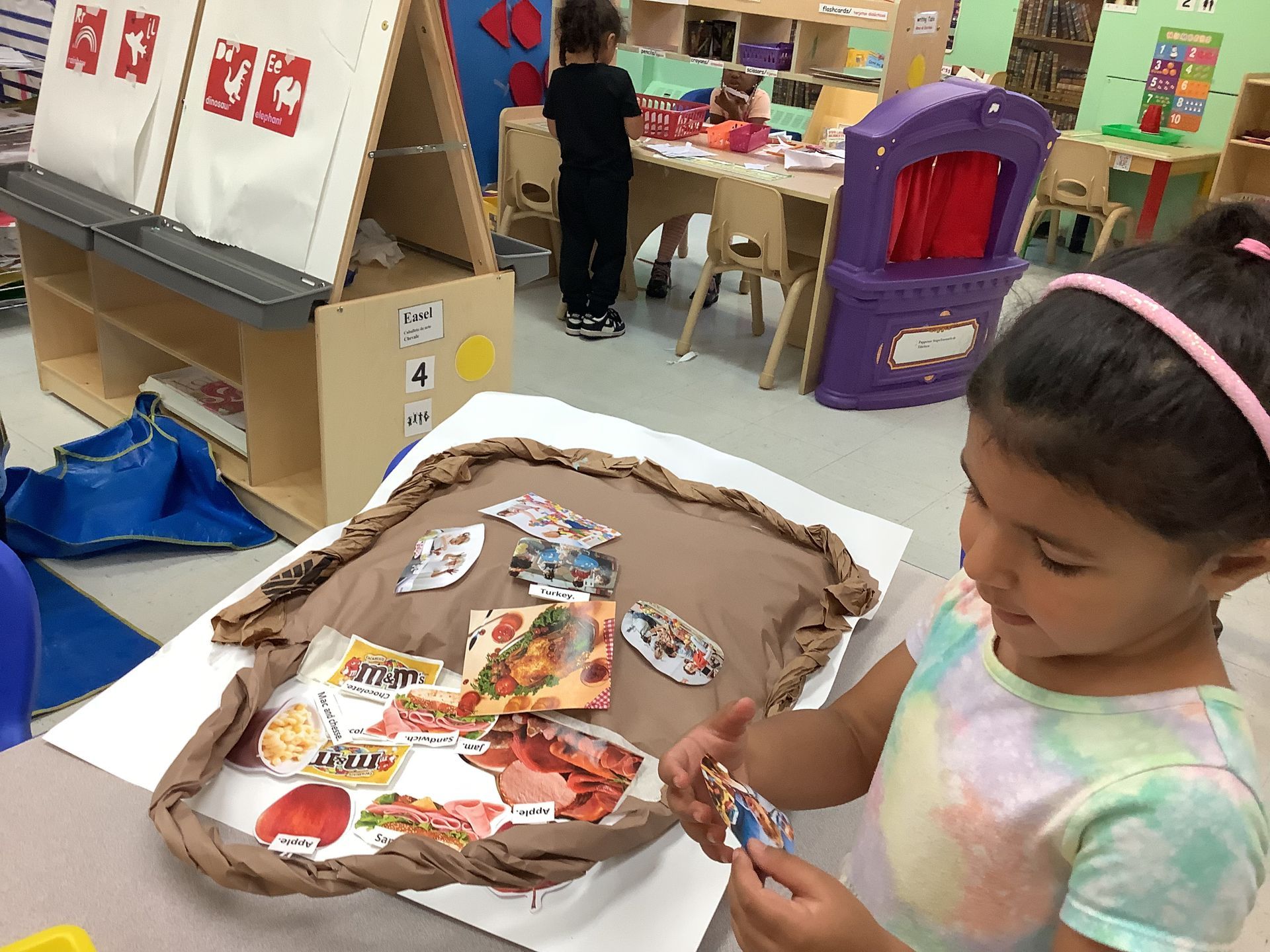 A little girl is looking at a piece of pizza on a table