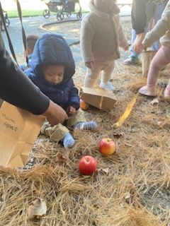 A group of children are playing in the dirt with apples